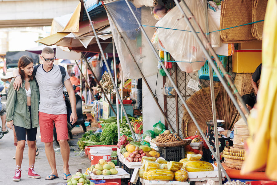 Un par de turistas caminan por un mercado tradicional chino.